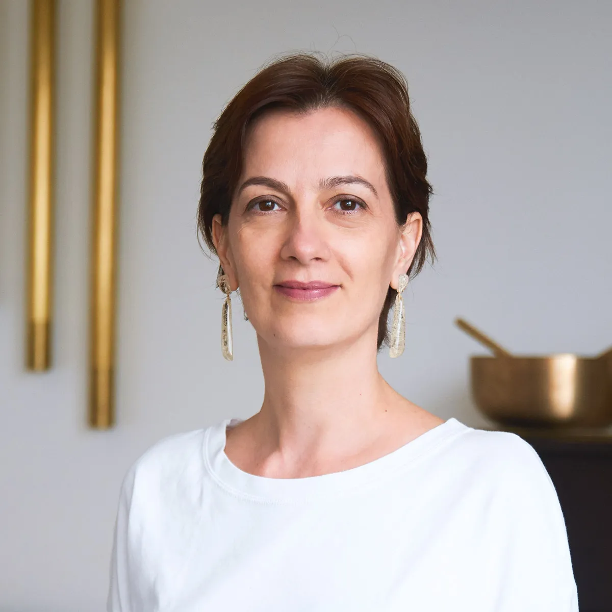 Suzana Brunhara, musicoterapeuta, em retrato de estúdio com instrumentos sonoros ao fundo